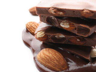 Pieces of tasty chocolate with almonds on white background, closeup