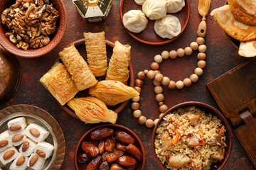 Fototapeta premium Traditional Eastern dishes with tasbih on color background