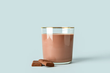 Glass of delicious chocolate milk on grey background