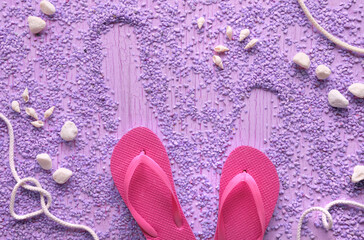 Summer by the sea. Magenta rubber flip-flops, slippers on pebbles with sea shells, cord and...