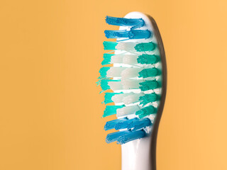 Close up view of electric toothbrush bristles.  Detailed shot of ultrasonic brush head on orange...