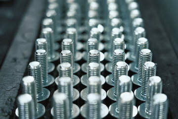 Many metal screw bolts as industrial equipment background.