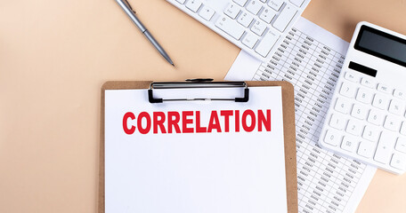 clipboard with white blank paper text CORRELATION , keyboard calculator and chart, top view....