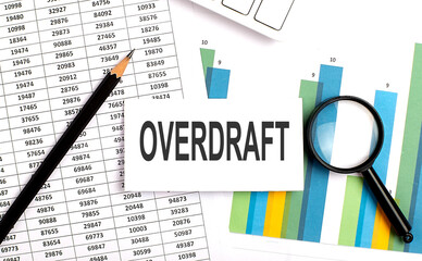 Obraz premium OVERDRAFT text on white card on the chart background