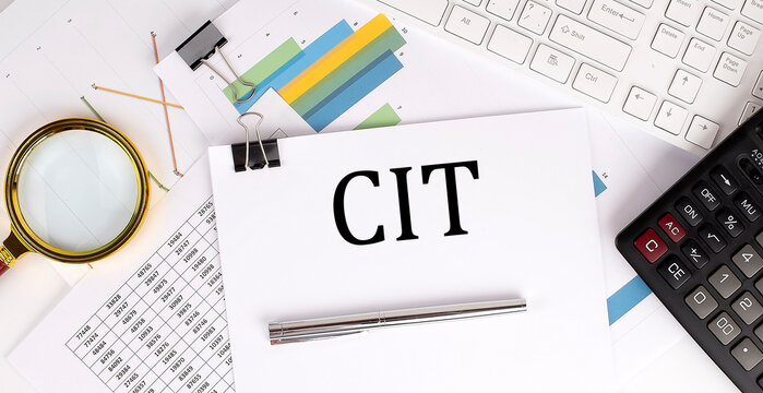 CIT text on the white paper on the light background with charts paper ,keyboard and calculator