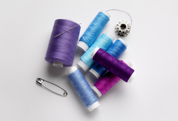 Thread spools and pin on white background