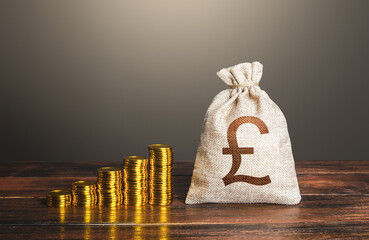 British pound sterling money bag and increasing stacks of coins. Rise in profits, budget fees....