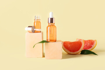 Composition with bottles of grapefruit essential oil and decor on color background