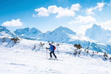 Fototapeta na wymiar Male skier skiing on snow covered landscape. Scenic mountain range against sky. Tourist enjoying adventure sport during winter.
