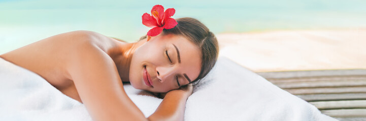 Obraz na płótnie Canvas Massage spa and Body care outside on beach at luxury vacation resort. Asian beauty woman relaxing sleeping lying on table during aromatherapy treatment with coconut oil