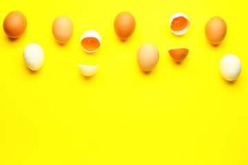 Cracked and whole chicken eggs on yellow background