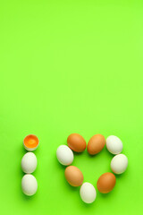 Composition with heart made of chicken eggs on green background