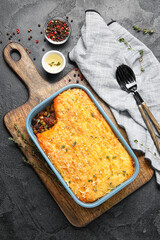 Baking dish with tasty Shepherd's pie on black background