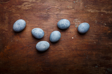 Blue diy painted easter eggs on brown wooden rustic table background. Copy space, top view