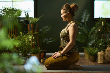 stylish 40 years old woman in green living room doing yoga