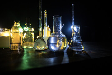 Obraz na płótnie Canvas Test glass flask with solution in research laboratory. Science and medical background. Laboratory test tubes on dark toned background , science research equipment concept