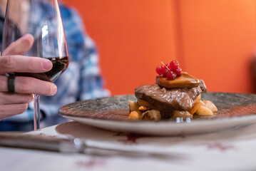 Man enjoying juicy dinner. Male tourist having delicious food with beverage on dining table. Meal is served in luxurious resort.