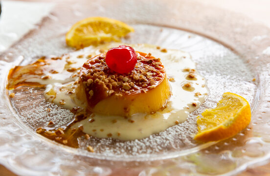 Delicate caramel tocino de cielo, sweet egg based pudding served with crushed nuts and fruits. Traditional Spanish dessert ..