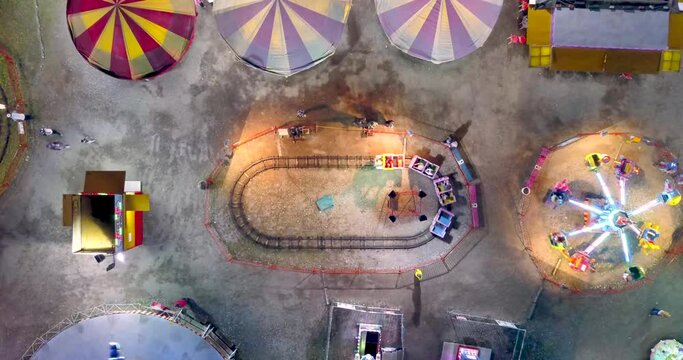 Aerial view top-down of mini train at funfair in 4K