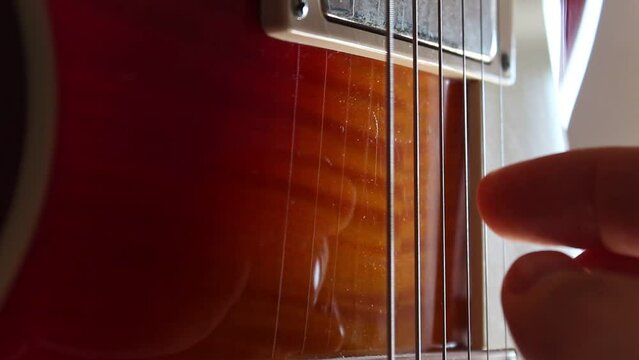 Fingerpicking nothing else matters on a cherry sunburst Les Paul guitar. Static close up shot