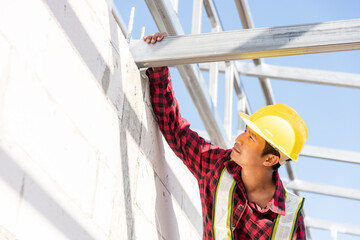 Construction worker or contractor checking house frame, worker roofer builder working on steel roof...