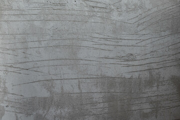 The cement wall has scratches. uneven plaster surface