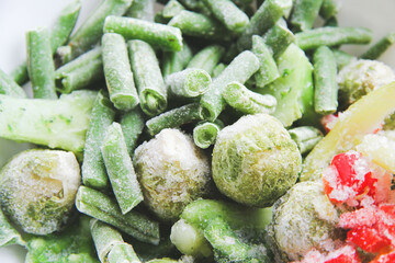 Frozen vegetables close up. Vegetables in the fridge. Ice on vegetables.
