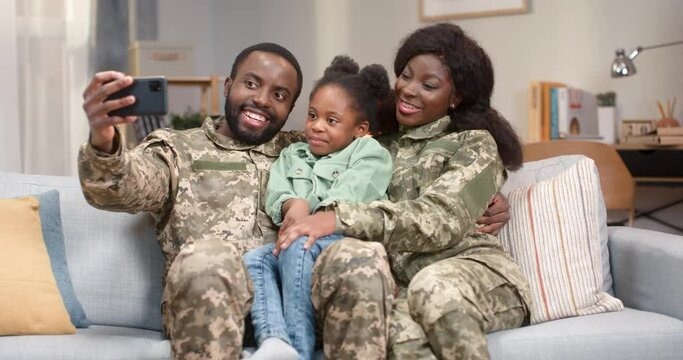 African american military couple taking selfie with daughter