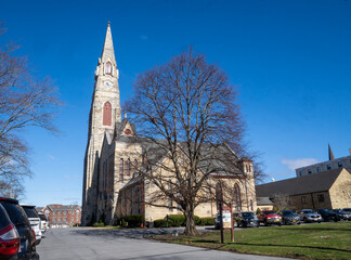 Obraz premium Goshen, NY - USA - April 2, 2022 - Landscape side view of the First Presbyterian Church. Erected in 1871, it features a three-panel Tiffany window.