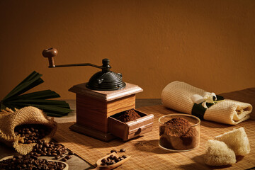 Close view of coffee grinder decorated with coffee pack and towel in wooden background for advertising 