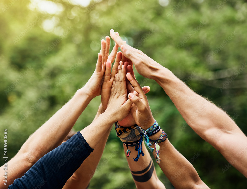 Poster time for some outdoor fun. shot of a group of unrecognizable peoples hands raised in the air to form