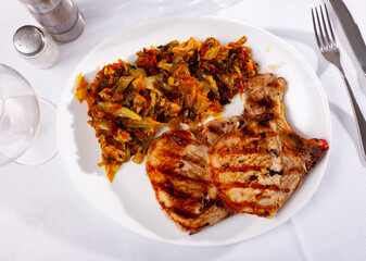 Tasty meat pork served with braised cabbage on a served table