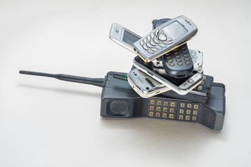 Pile of old and obsolete mobile phones on space of bright and rough background
