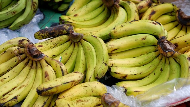 Stacks of ripe banana fruit in traditional market 