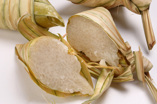 Traditional diamond shaped woven palm leaf pouch steamed glutenous rice cake ketupat kupat tipat on white background