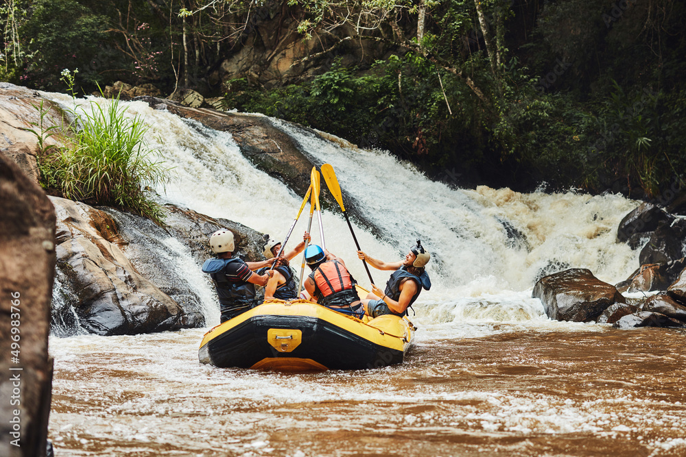 Poster Go where you feel most alive. Shot of a group of friends out river rafting on a sunny day.