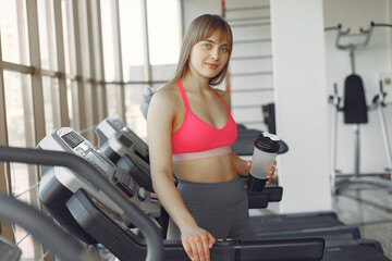 Fototapeta premium A beautiful girl in a gym on a racetrack