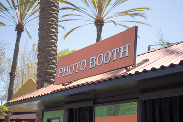 A view of a photo booth kiosk sign, seen in a public community recreation area.