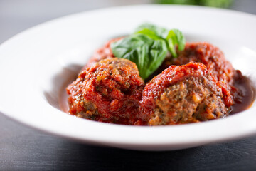 A closeup view of a plate of meatballs in marinara sauce.