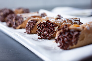 A view of a plate of small cannoli desserts.