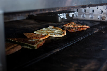 A view of pizza slices inside an industrial sized pizza oven, seen at a local pizzeria.