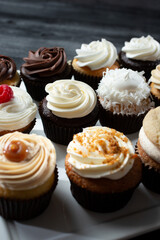 A view of several different varieties and flavors of cupcakes. 