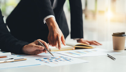 Businessman and woman discussing on stockmarket charts in office