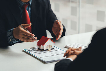 The real estate agent is explaining the house style to the clients who come to contact to see the...