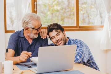 Son and Elder Father happy moment together looking at laptop for good memory.