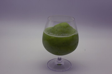 Fototapeta na wymiar Kiwi smoothie in a tall, large clear glass.Include Clipping Path.