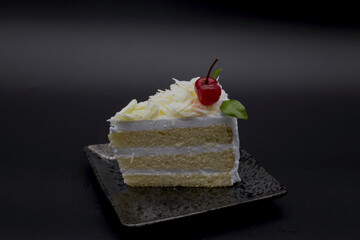 Dessert, fresh milk cake, white chocolate, cherries, placed on a plate, black background,Include Clipping Path.