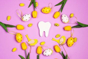White tooth with Easter decorations on purple background. Dentist Easter concept.