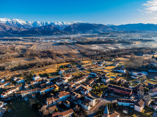 Central Friuli villages seen from above. Between hills and snow-capped mountains. Raspano di...