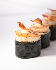Sushi maki roll on white background. Macro close up of low-carb KETO sushi with shirataki rice, scallop, bacon. Ketogenic diet, rice free. Japanese cuisine restaurant menu. Vertical, selective focus